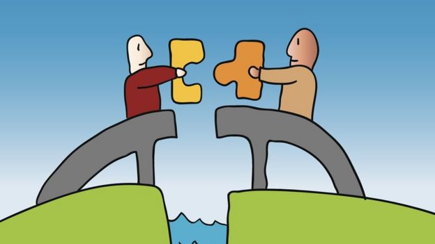 Two men holding separate pieces of a puzzle over a rift