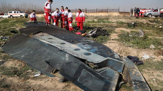 Rescatistas junto a restos del avión de Ukraine International