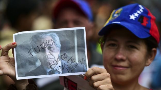 Una mujer con una foto de Luis Almagro