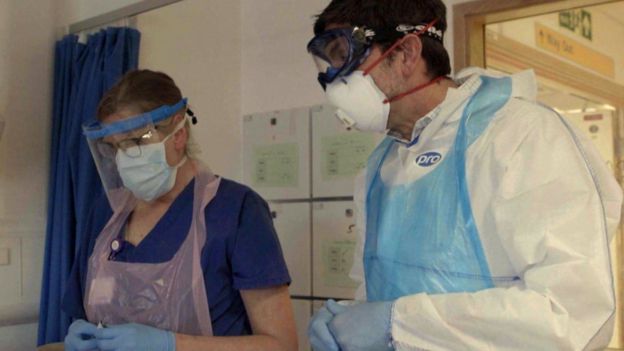 Image captionThe BBCs Justin Rowlatt with nurse Sandy Aitken at a patients bedside