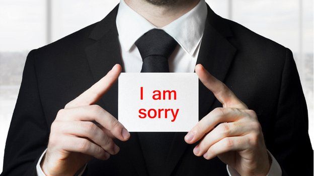 Businessman holds sign saying I am sorry