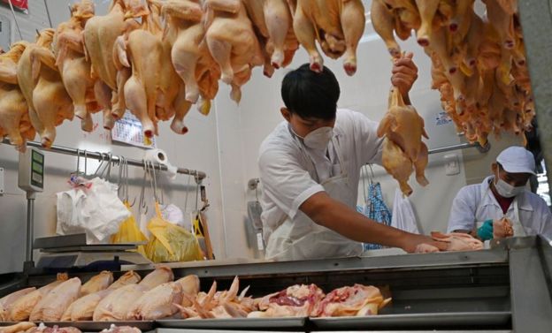 Vendedores con mascarillas en un puesto de pollo en un mercado de Lima el 18 de marzo de 2020.