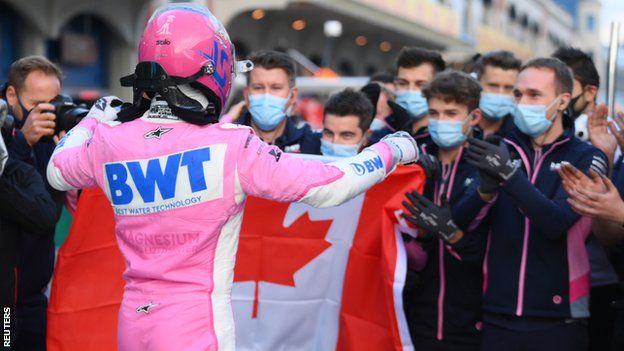 Lance Stroll holds up a Canadian flag