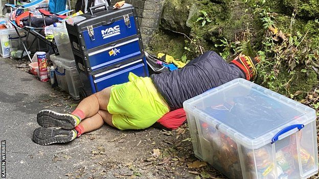 A runner lies on the ground outside the tunnel