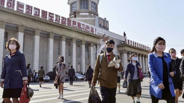 People wear face masks in front of Pyongyang Station in Pyongyang, North Korea (27 April 2020)
