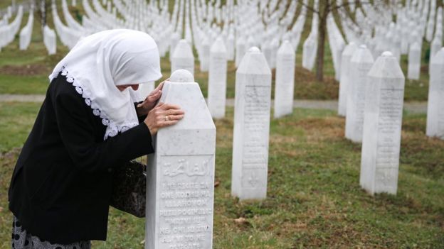 Una mujer llora junto a una tumba en el memorial por las víctimas de Srebrenica.