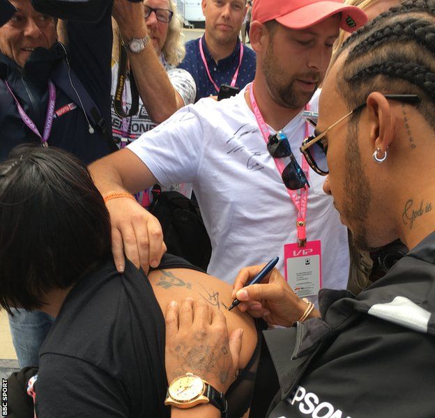 Lewis Hamilton sings a fan's back