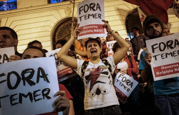 Ciudadanos sujetan carteles en protesta contra Temer.