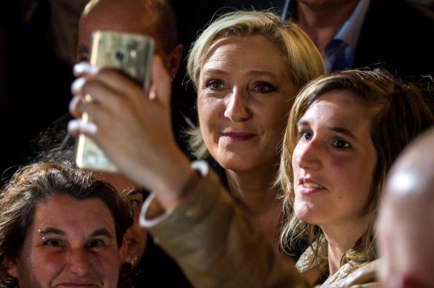 Marine Le Pen (C) poses for a selfie photo during a campaign rally on 8 June in Calais