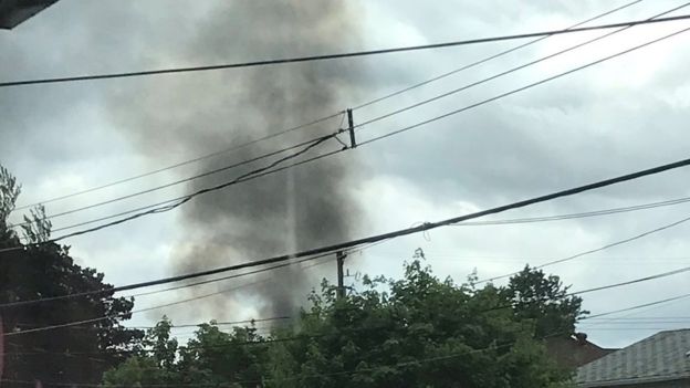 A plume of smoke rises over houses in Kamloops