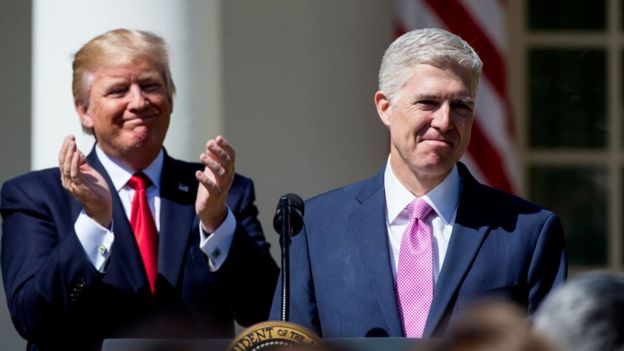 Donald Trump claps as he watches Neil Gorsuch take the Supreme Court oath of office.