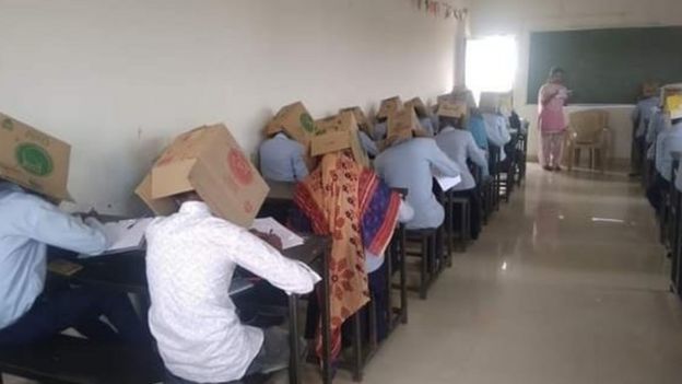 Fotos mostram estudantes indianos fazendo prova com caixa de papelão na cabeça
