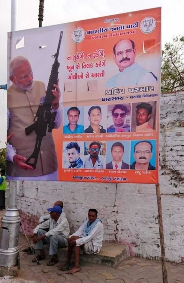 A billboard displaying an image of Indian Prime Minister Narendra Modi holding a rifle is seen on a roadside in Ahmedabad on March 3, 2019.