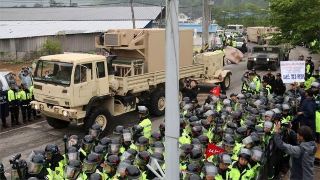 Police and protesters line the road as Thaad equipment is moved into place (26 April 2017)