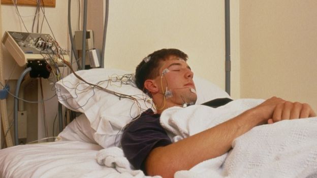 Voluntario durmiendo, con cables conectados a su cabeza