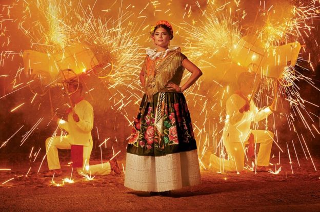 Una mujer posa durante una festividad con fuegos pirotécnicos.
