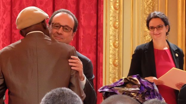 Un tirailleur recevant le titre de sa naturalisation des mains de François Hollande