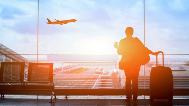 Una mujer en un aeropuerto esperando su vuelo.
