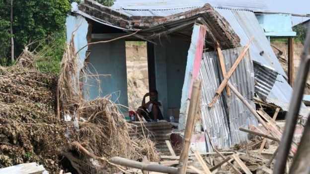 Un hombre está sentado en medio de sucasa destruida durante las fuertes lluvias en Katmandú, la capital de Nepal.