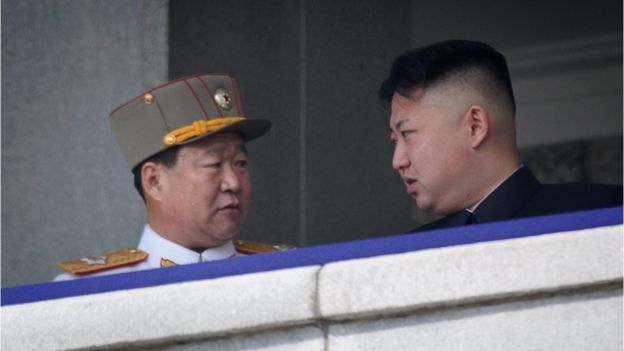 崔龙海与金正恩对望。