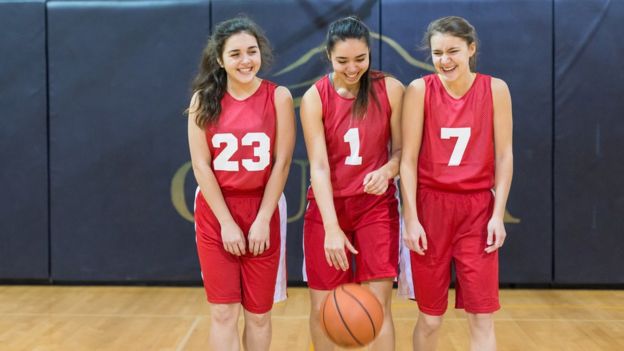 Tres adolescentes miembros del mismo equipo de baloncesto.