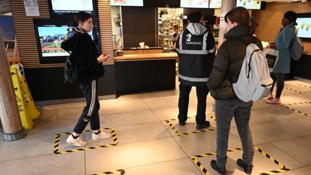 Tape in a fast food store marks the floor where customers should stand to practice social distancing. Image: EPA