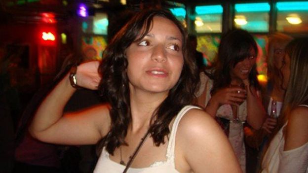 Meredith Kercher, a young woman with dark hair, poses in a lively bar scene in this 2007 handout photo