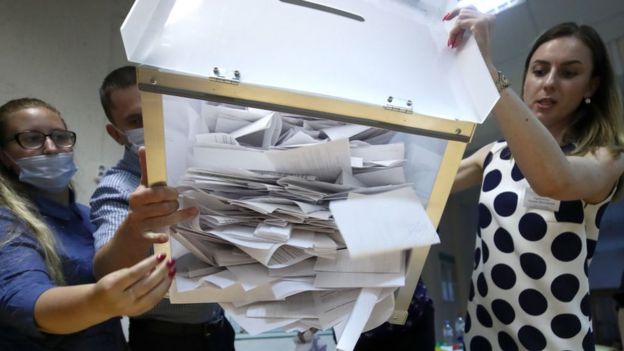 сотрудники участка в Минске опрокидывают урну с бюллетенями