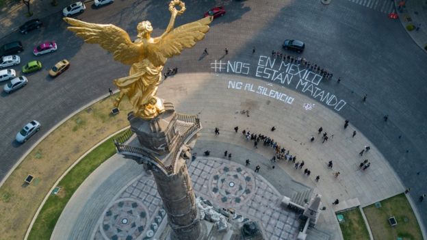 golden angel statue with Spanish words painted on the road