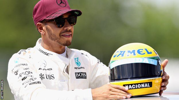 Lewis Hamilton with a helmet commemorating Ayrton Senna after beating the Brazilian's tally of 65 pole positions