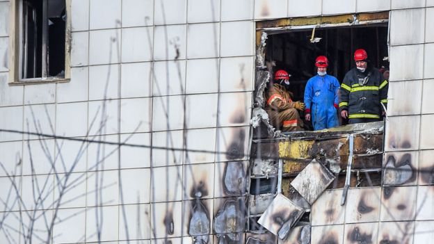 Russian emergency service staff work at the site of a fire at a multi-storey shopping centre in Kemerovo on March 27, 2018