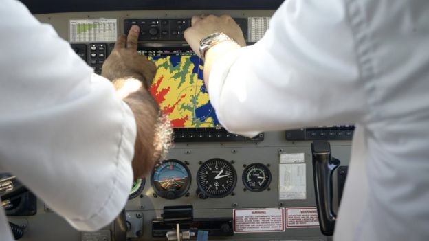 Piloto y copiloto aprietan botones en la cabina del avión.