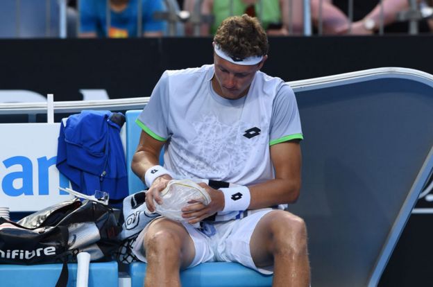 El tenista uzbeko Denis Istomin se coloca una bolsa de hielo en la pierna durante un partido.