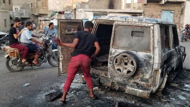 File photo showing a man looking at a burnt car in the Yemeni city of Taiz on 23 March 2019