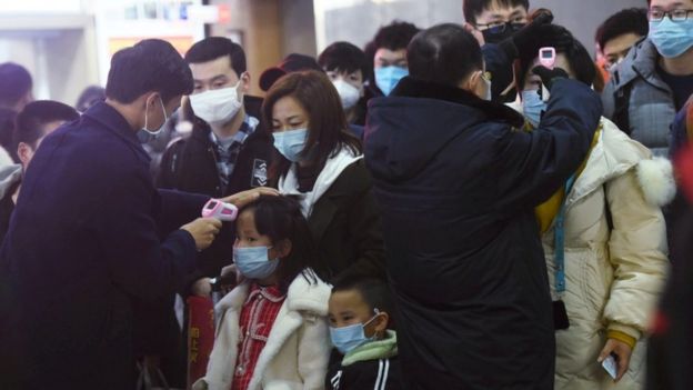 فرق المتابعة الصحية في الصين تقيس درجات حرارة الأشخاص القادمين من مدينة ووهان إلى مدن أخرى في أنحاء البلاد.