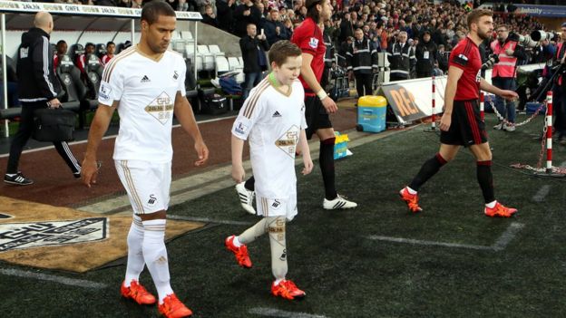 Swansea City mascot with player
