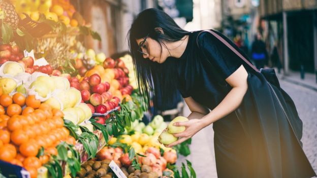 Woman Buying Fruits on Street Market - stock photo