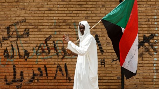 متظاهر يحمل علم السودان