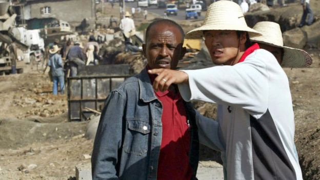 A Chinese construction worker (R) supervises the building of a road in Addis Ababa, 27 April 2007