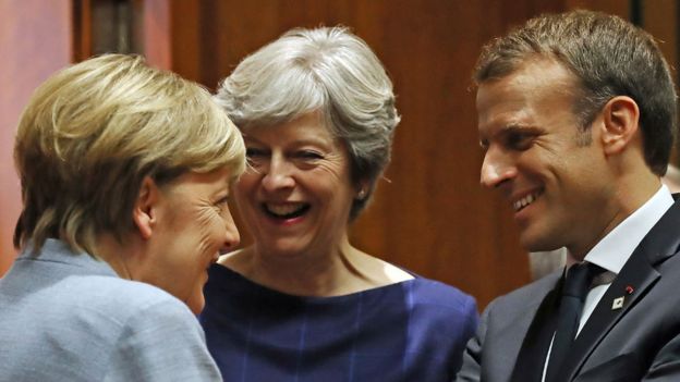 Merkel, May and Macron share a joke in Brussels in 2017