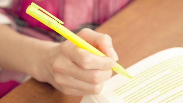 طالب يظلل بقلمه بعض أسطر الكتاب