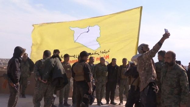 Combatentes sírios erguem bandeira amarela para celebrar derrota do EI