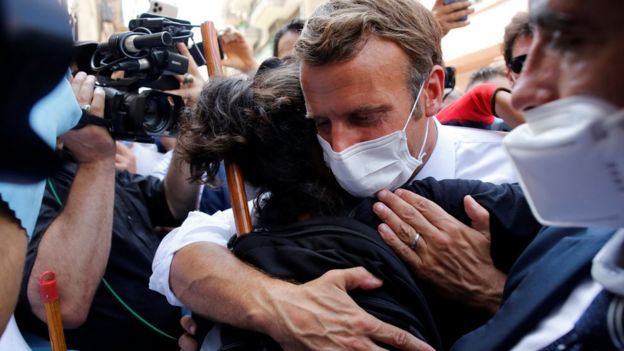 Emmanuel Macron hugs a Beirut resident