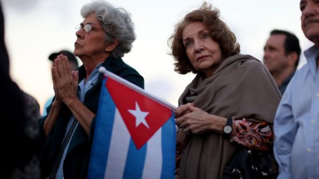 Mujer sostiene una bandera cubana.