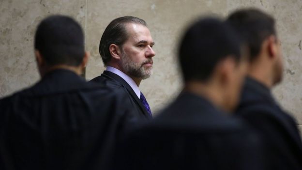 Dias Toffoli aparece de perfil em meio a outros homens no STF