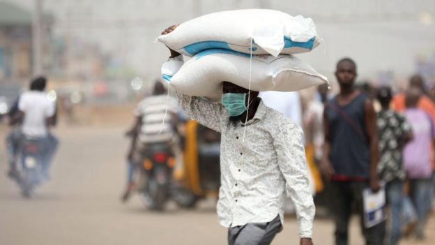 A man carrying bags of rice