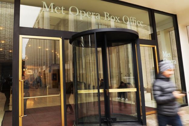 People walk outside the doors of New York's Metropolitan Opera