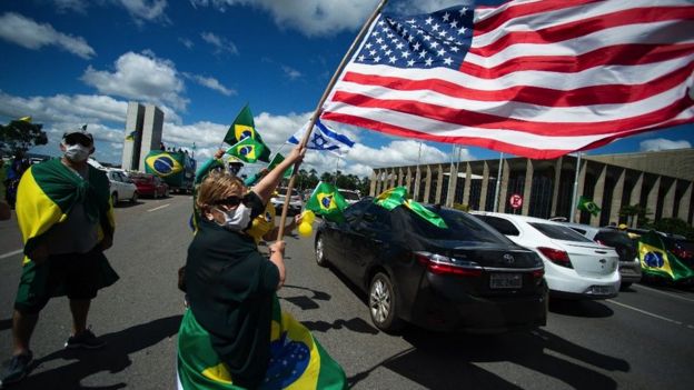 A motorcade against lockdown measures gathers in front of Brazil's Congress building in Brasilia, 26 April 2020