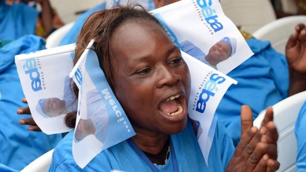 A supporter pinned electoral flags of Beninese businessman and presidential candidate Sebastien Ajavon during a rally in Cotonou, on March 4, 2016