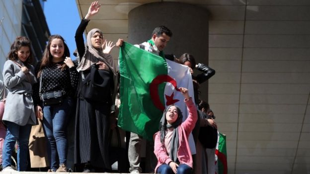 Algerian medical students hold up a flag at an anti-government protest in Algiers